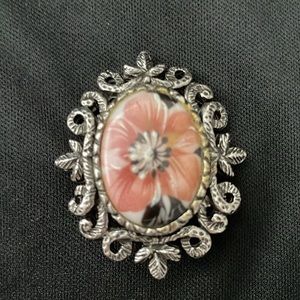 Antique women pin. Bronze trim with a pink flower on the center.